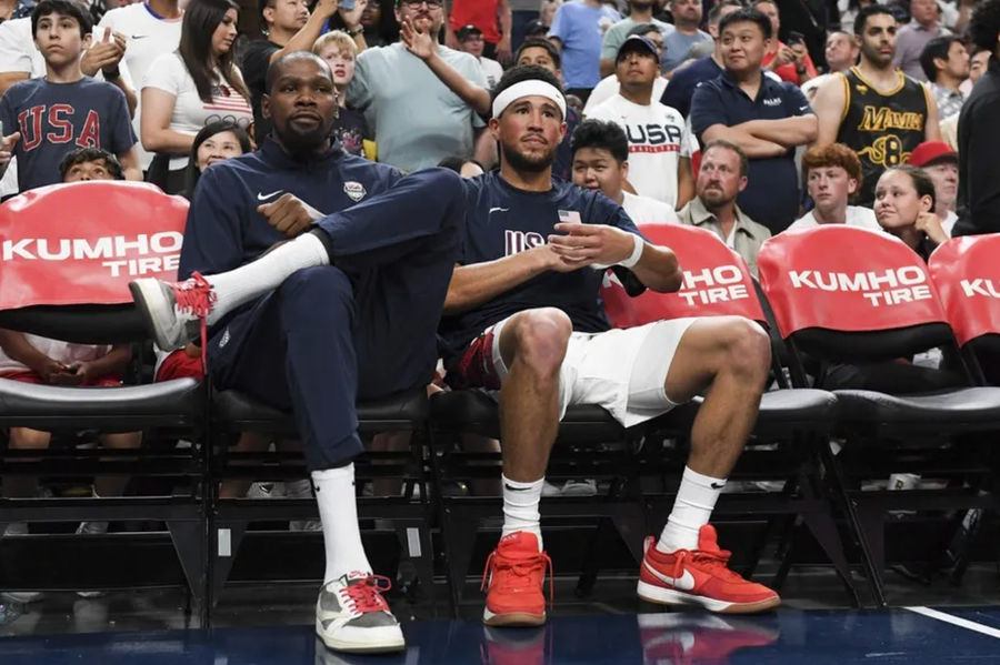 Jul 10, 2024; Las Vegas, Nevada, USA; USA forward Kevin Durant (7) and guard Devin Booker (15) look on from the bench during the fourth quarter against Canada in the USA Basketball Showcase at T-Mobile Arena. Mandatory Credit: Candice Ward-USA TODAY Sports