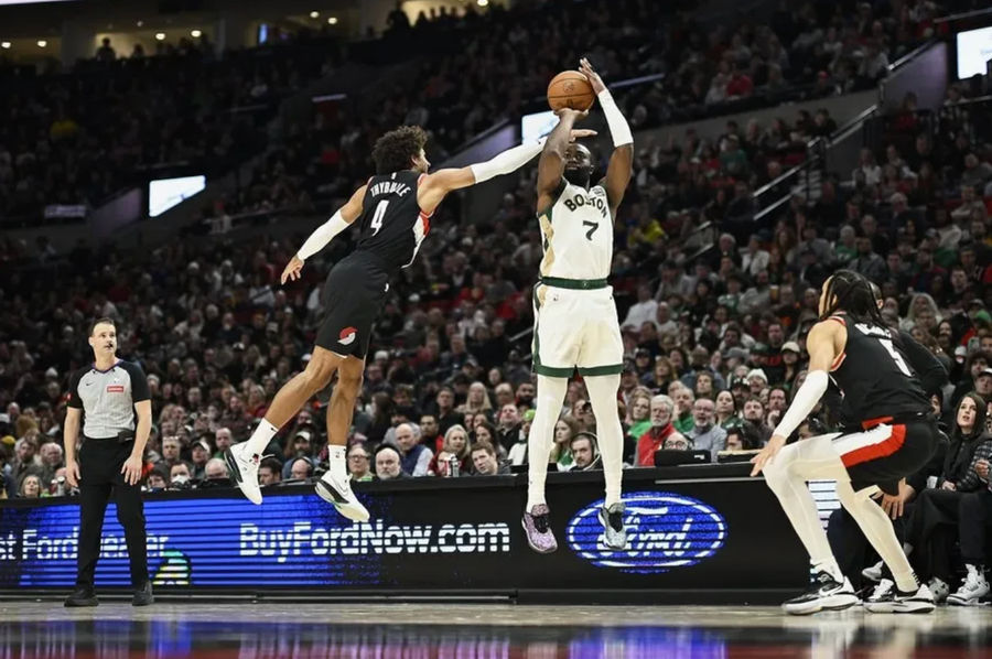 Mar 11, 2024; Portland, Oregon, USA; Boston Celtics guard Jaylen Brown (7) shoots a three point jump shot during the first half against Portland Trail Blazers guard Matisse Thybulle (4) and guard Dalano Banton (5) at Moda Center. credits: Troy Wayrynen-USA TODAY Sports